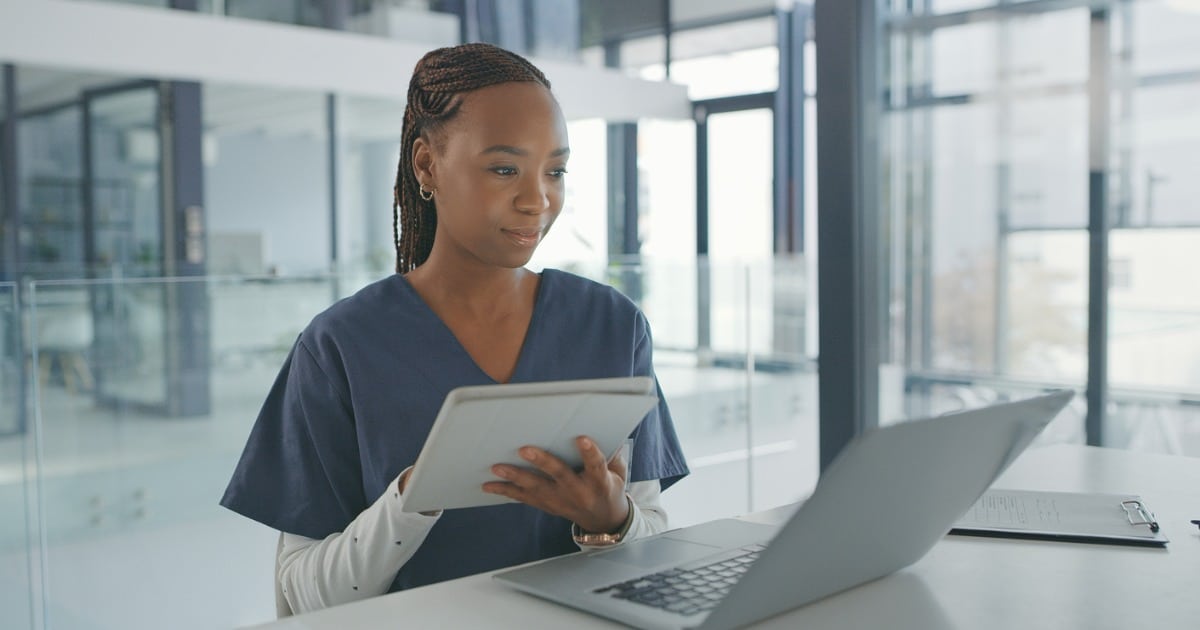 Dental professional looking at a laptop.