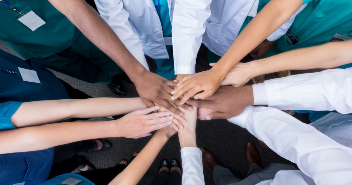 A group of people handstacking.